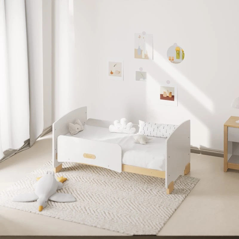 White and natural-wood cot bed converted into a low toddler bed with a guard panel, in a bright bedroom White and natural-wood cot bed converted into a low toddler bed with a guard panel, in a bright bedroom